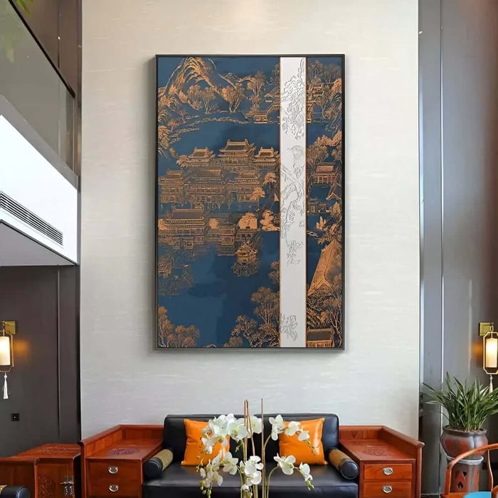 Tall blue and gold Asian landscape painting with temples hanging above a black sofa in a formal living room.