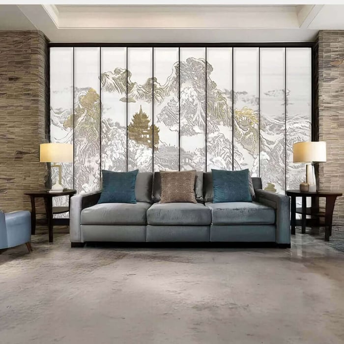 Grey sofa in a modern lounge with a large multi-panel mountain landscape wall mural behind it.