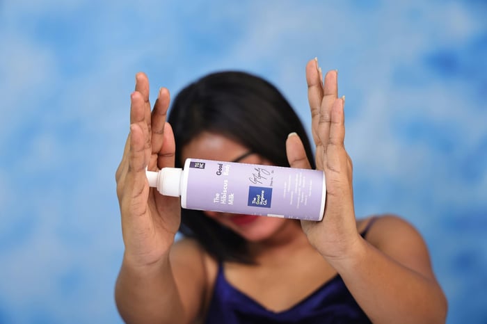 Woman holding a bottle of skincare product