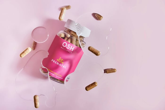 A pink box of pills and a glass of water