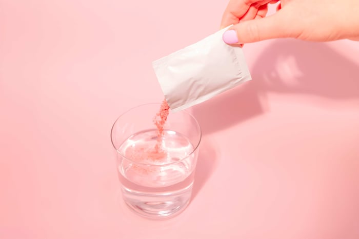 A person pouring a drink into a glass