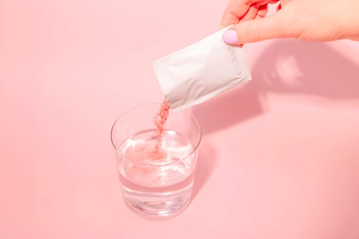 A person pouring a drink into a glass