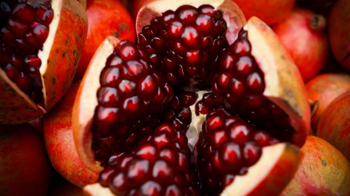 A close-up of an open pomegranate full of seeds