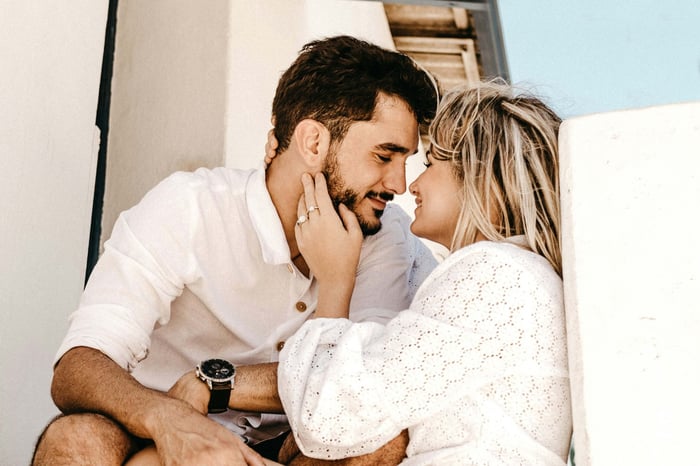A couple look at each other intimately before kissing