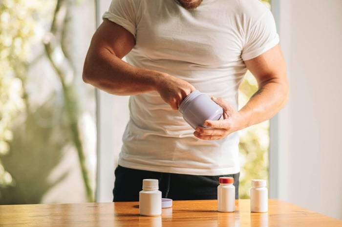 A ripped looking guy using setting up his supplement stack