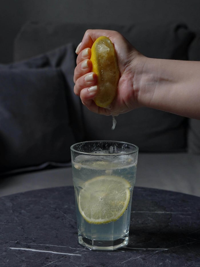 person supplementing their water with lemon to get hydration benefits