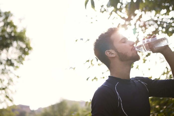 a man outside incorporating drinking water to his morning habits fueling his focus, mood and digestion throughout the day.