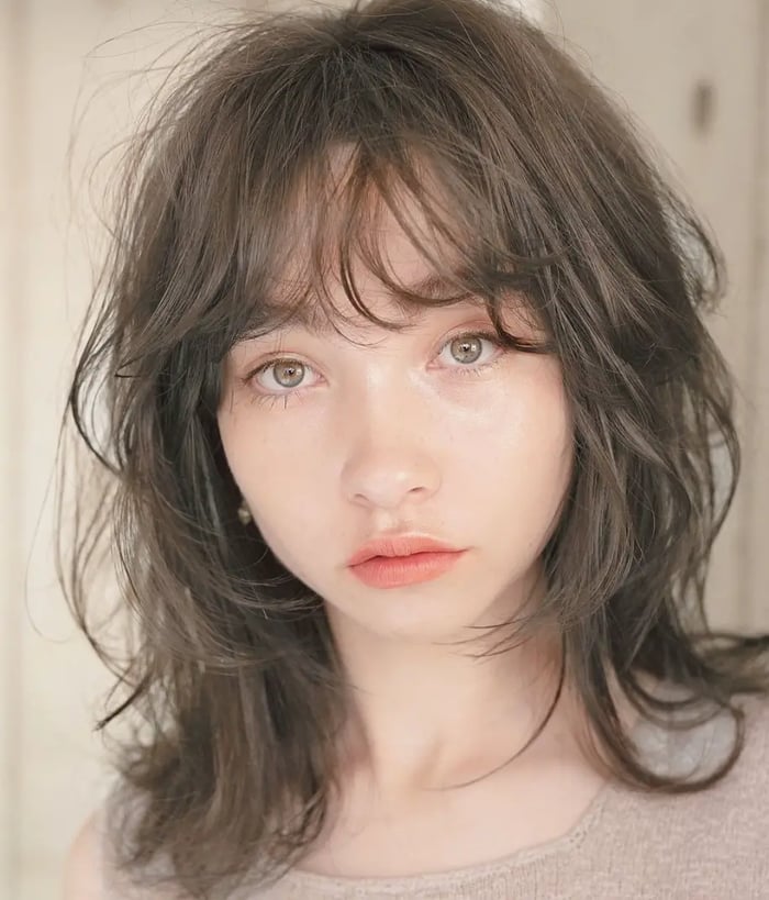 Paired with naturally flowing medium-length hair, French bangs adds a touch of carefree allure, softening your features and creating a harmonious balance. 
