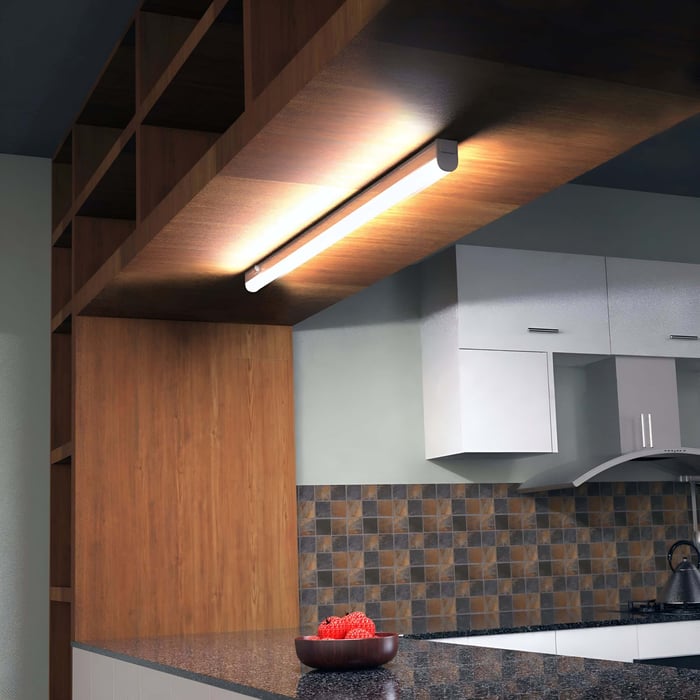 Linear under-cabinet light mounted beneath open shelving, creating a warm glow on the counter.