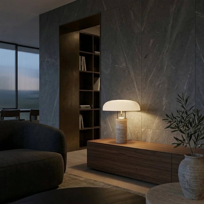 Elegant mushroom-style lamp with a stone base on a dark wood console against a grey marble wall.