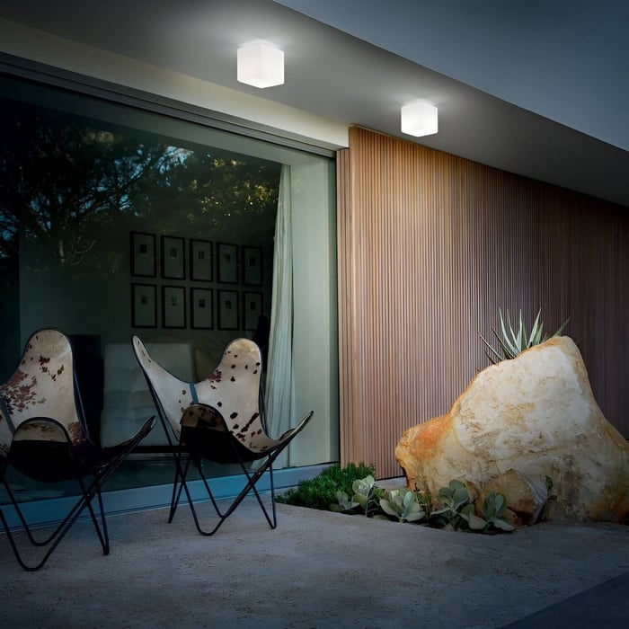 Contemporary patio with cube ceiling lights casting soft light over butterfly chairs and vertical wood slat wall.