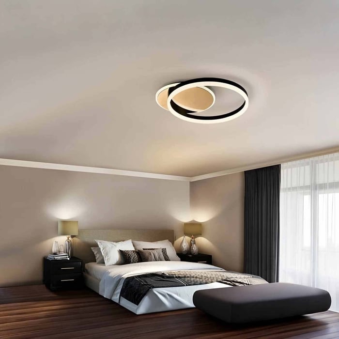 Modern circular LED ceiling light in a cosy bedroom with warm ambient lighting.