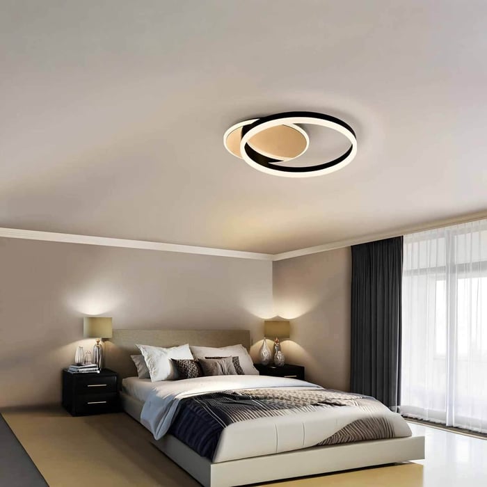 Modern bedroom with circular LED flush mount ceiling light.