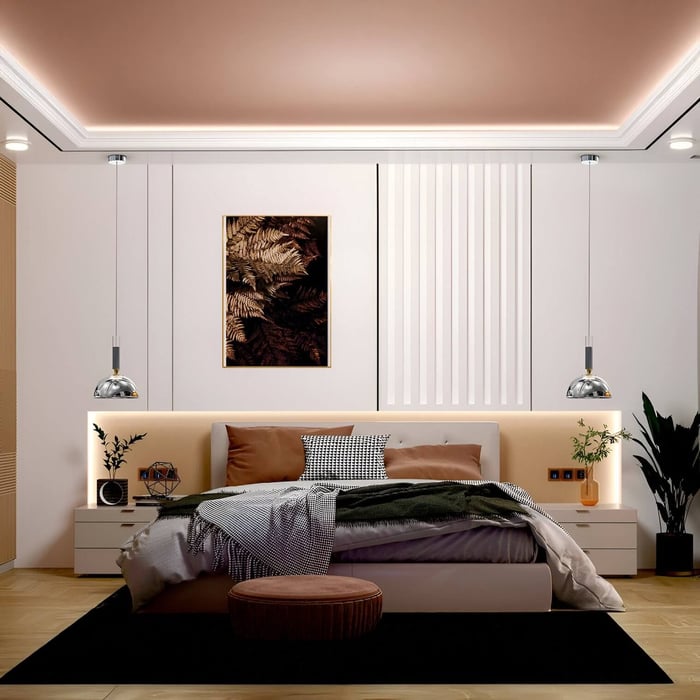 Warm bedroom with pink ceiling lights, chrome pendant lamps, and neutral-toned furniture accented by dark throw pillows.