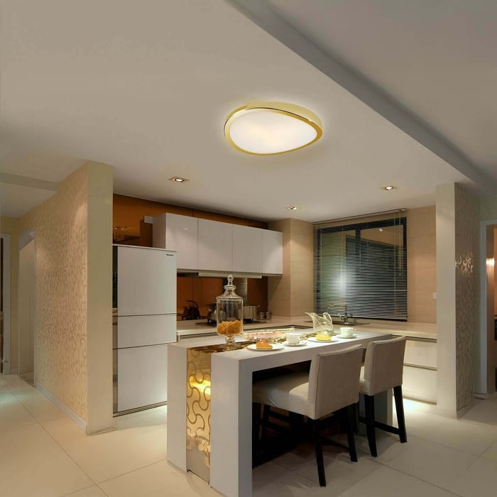 Compact modern kitchen with beige tones, dining counter, and a circular flush-mount ceiling light.