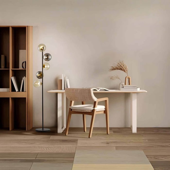 Slim floor lamp with mixed glass globe shades beside a minimalist desk in a home office.
