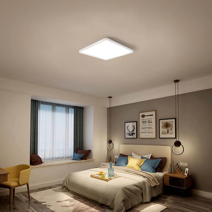 Bedroom interior with a square LED panel ceiling light above the bed and pendant bedside lights.