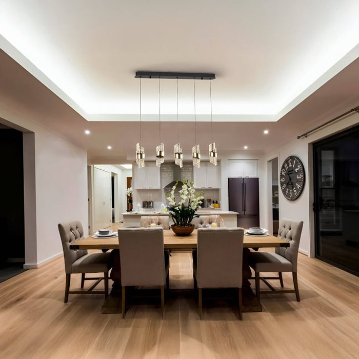 Contemporary dining area with six-glass pendant chandelier above a wooden table, upholstered chairs, and recessed ceiling lights.
