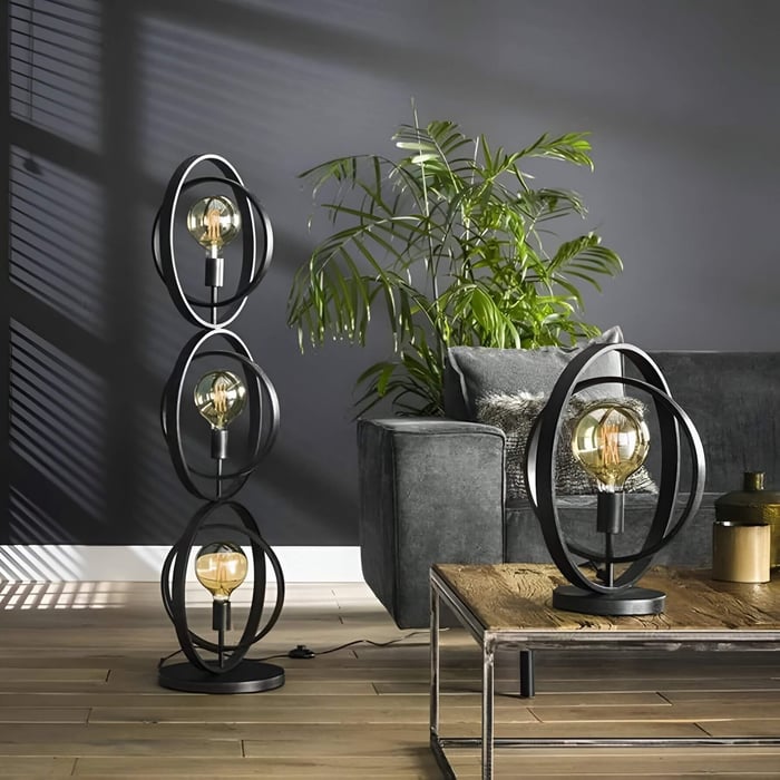 Black metal ring floor and table lamps with exposed filament bulbs in a modern living room.