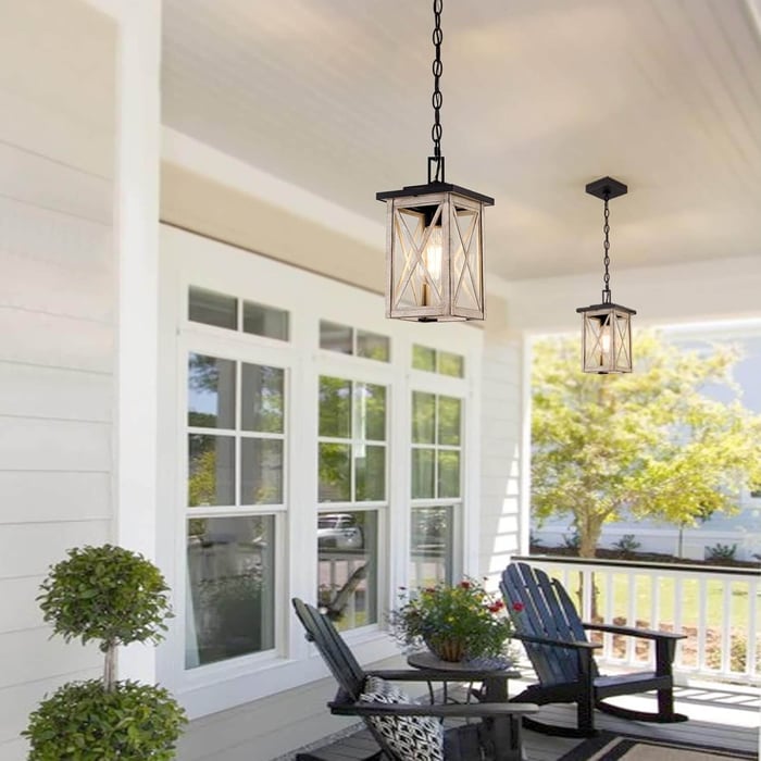 Bright farmhouse-style porch with two lantern pendant lights hanging above outdoor chairs.