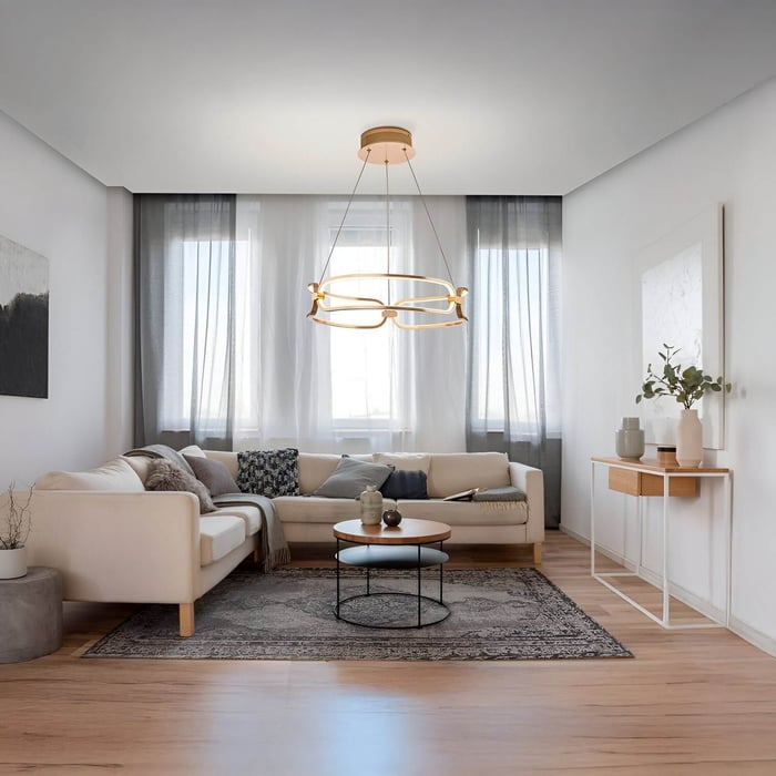 Contemporary gold chandelier with organic loops above a neutral living room with sectional sofa and minimalist decor.