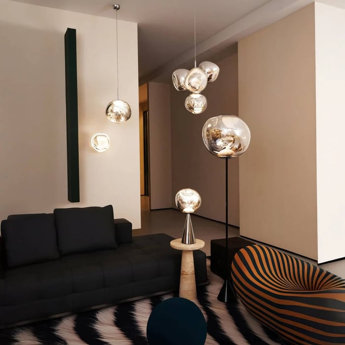 Modern living room with mirrored glass globe pendant lights and matching floor and wall lamps.