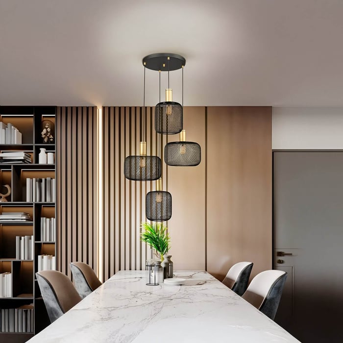 Multi-drop black mesh pendant lights with gold accents above a marble dining table in a contemporary space with wood panel walls.