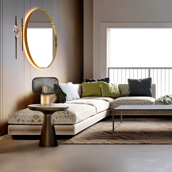 Modern living room with cream sectional sofa, sculptural mesh table lamp, and gold wall mirror with indirect lighting.