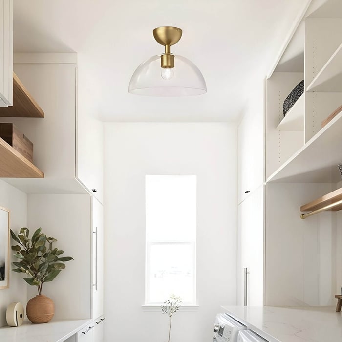 Bright white laundry or pantry room with wooden accents and a half-dome glass and brass ceiling light.