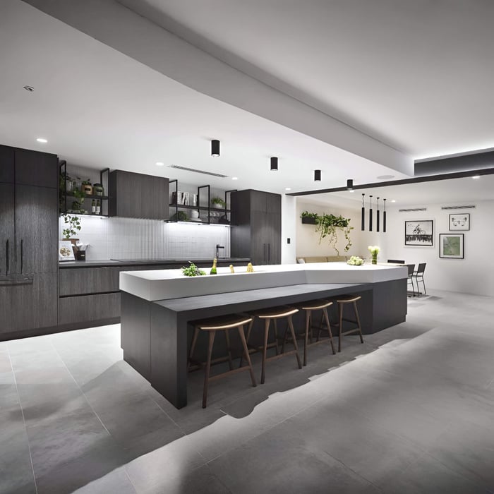 Spacious open-plan kitchen with a long island, ceiling downlights for general lighting, and pendant lights over the dining area.