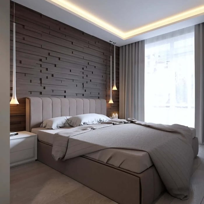 Modern bedroom with warm cove LED strip lighting around the ceiling, a padded headboard, and pendant lights beside the bed.