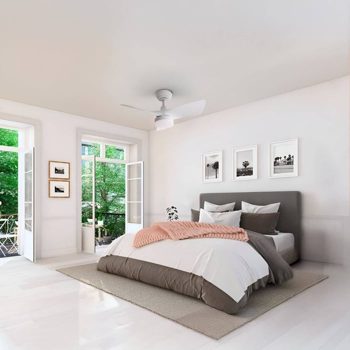 Minimal white ceiling fan with light above a modern bedroom with natural light.