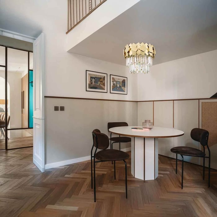 Gold semi-flush ceiling light over a round dining table in a bright, contemporary space.