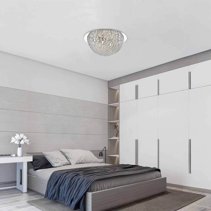 Modern grey-and-white bedroom with a round recessed crystal ceiling light centred overhead.