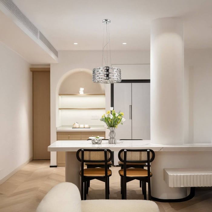 Modern kitchen with white island, black chairs, and a crystal pendant light hanging above the dining counter.