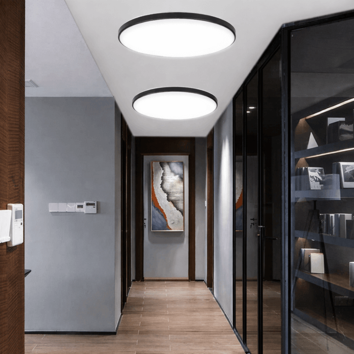 Modern hallway with two large round flush ceiling lights creating soft, even ambient lighting.