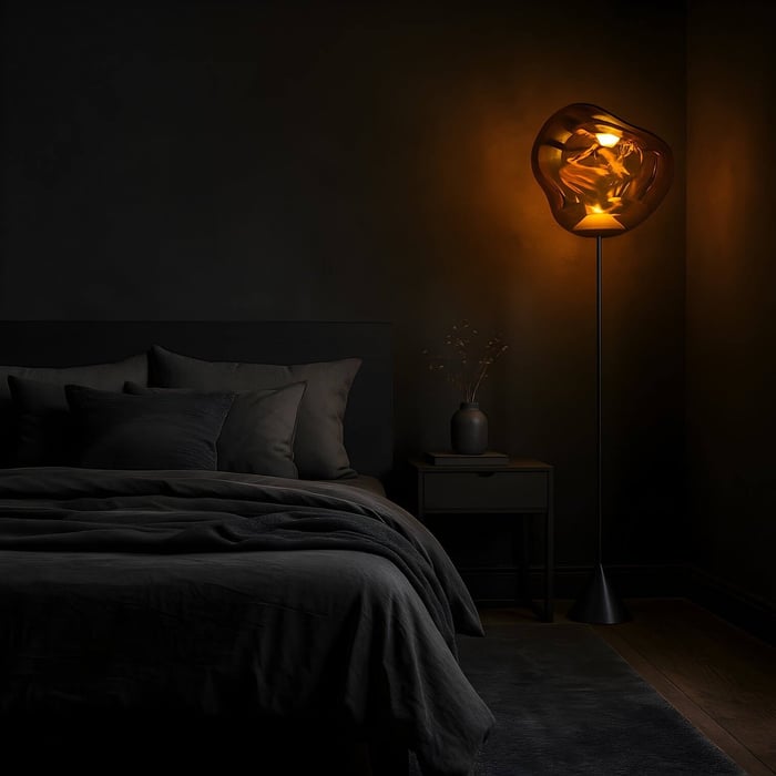 Sculptural amber floor lamp casting warm glow in a dark modern bedroom.