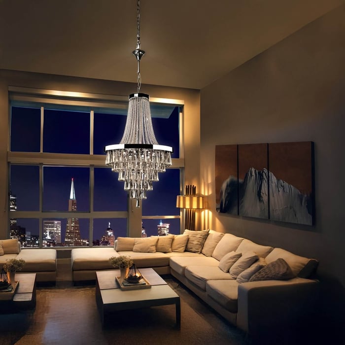 Elegant crystal chandelier hangs over a beige sectional in a high-rise living room with city skyline view.