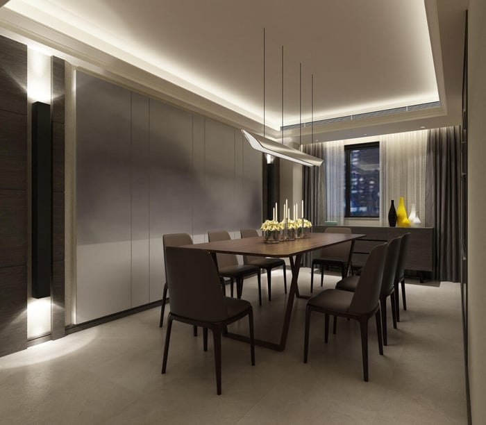 Modern dining room with cove ceiling LED strip lighting and pendant lights above a dining table, creating even ambient illumination.