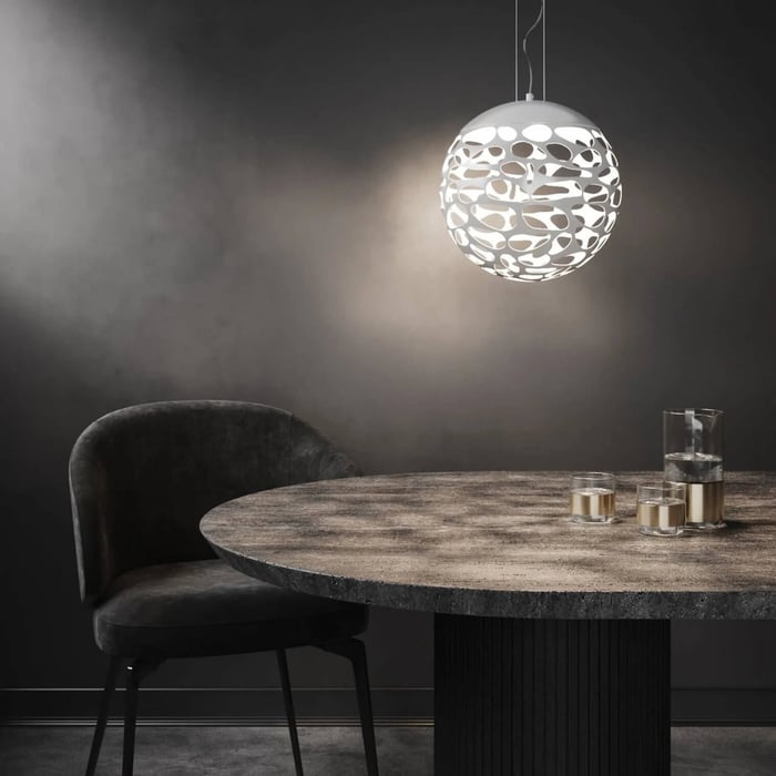 Dark dining setting with a white patterned globe pendant light casting soft shadows above a round table.
