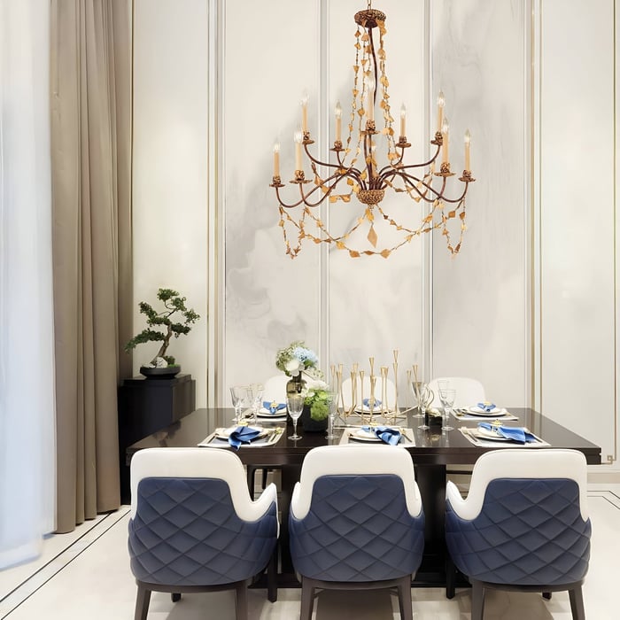 Rustic bronze chandelier with candle lights and leaf accents above a modern dining table.