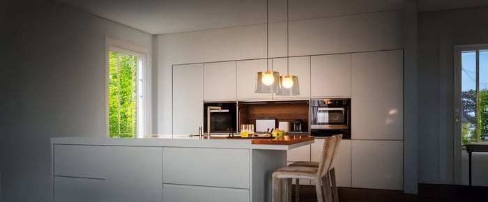 A white kitchen design bathed in natural light, featuring pendant kitchen lights over the island for a clean and inviting ambiance.