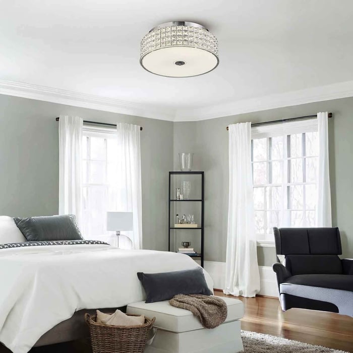 Light, airy bedroom with crystal flush-mount ceiling light and large windows.