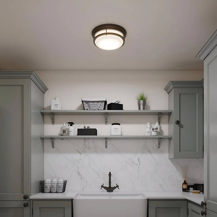 Flush-mount ceiling light illuminating a white utility room with open shelves and farmhouse sink.