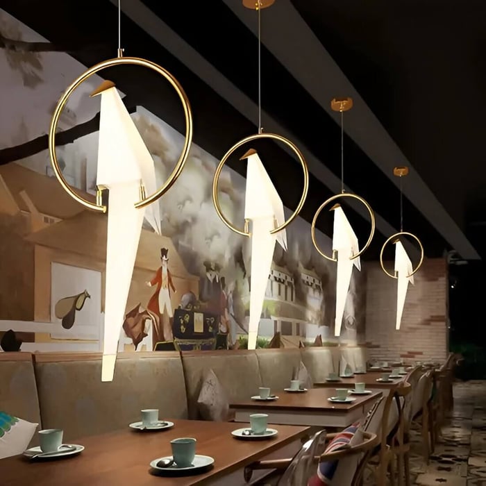 Bird-shaped pendant lights in a row above restaurant tables and booth seating.