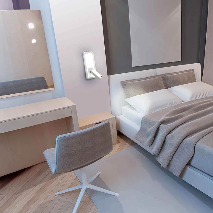Modern bedroom/workspace with a white adjustable wall spotlight beside the bed and a compact desk and chair.