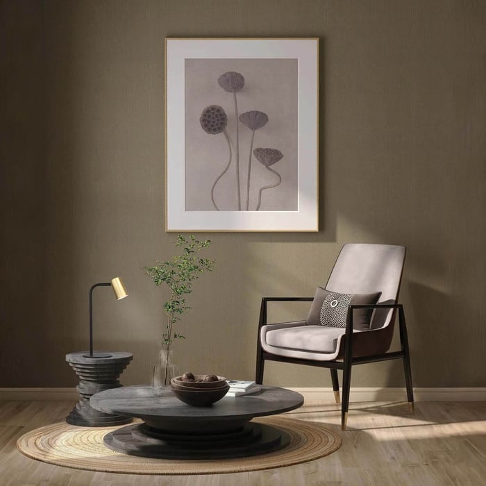 Black-and-brass industrial table lamp on a sculptural side table in a minimalist living room.