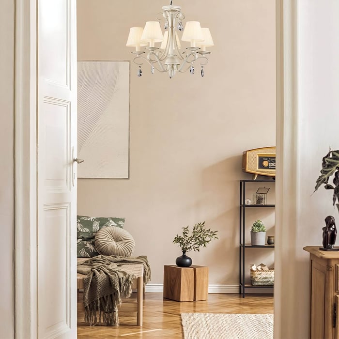 Transitional room view with white chandelier, vintage radio shelf, wood bench, and potted greenery for cozy decor.