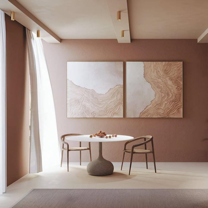 Minimalist dining space with gold surface-mounted downlights highlighting textured wall art and round table.