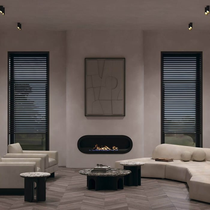 Modern living room with black surface-mounted downlights illuminating a curved wall fireplace and neutral seating.